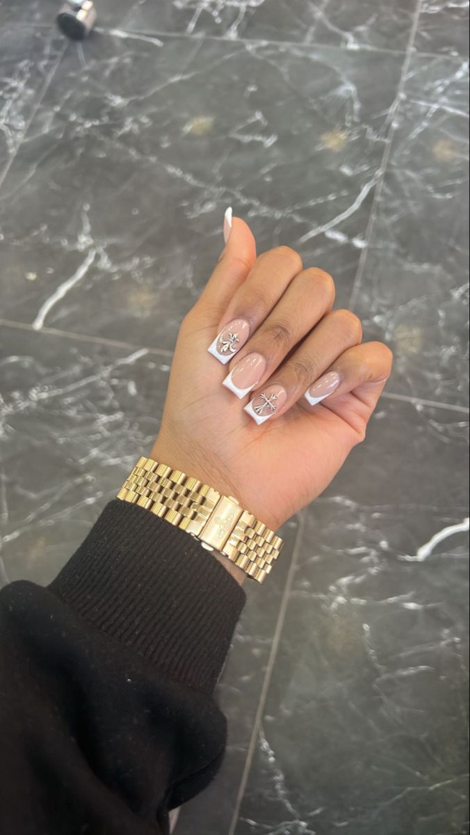 Sophisticated French Tip Nail Design with Glamorous Star Accents and Chic Gold Bracelet.