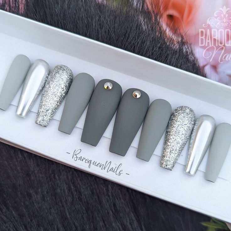 Sophisticated Matte and Glitter Nail Design with Gray and Silver Accents and Subtle Gemstone Glamour.