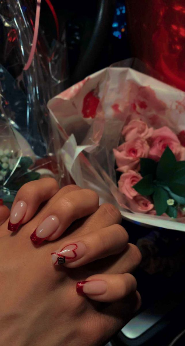 Romantic Nude and Red Glitter Nail Design with Heart Accent for Special Occasions.