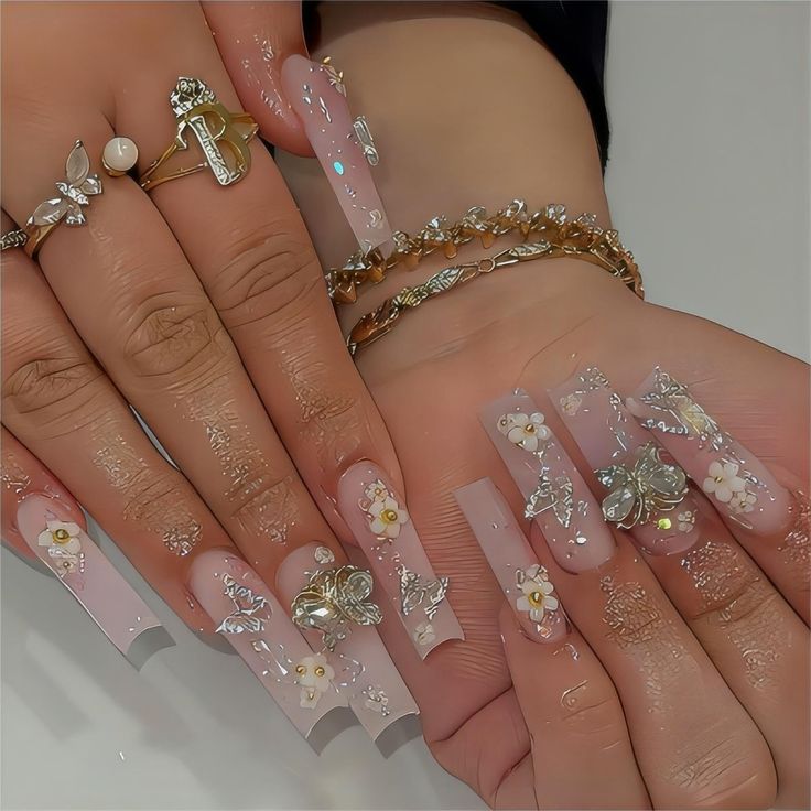 Glamorous Floral-Inspired Long Glossy Nail Design with Silver Butterflies and Sparkling Details.