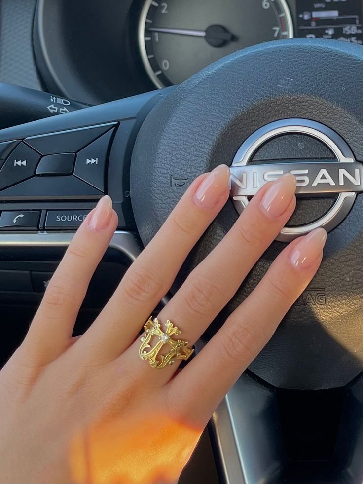 Elegant Nude Nails with Subtle Shine and Sophisticated Gold Ring.