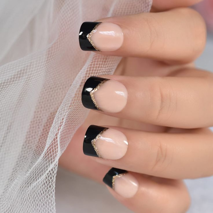 Chic Black and Nude French Tip Nail Design with Gold Chevron Accents.