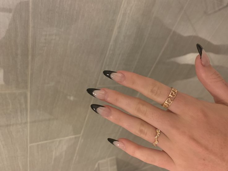 Chic Ombre Long Nails with Striking Nude and Black Tips, Accented by Delicate Gold Rings.