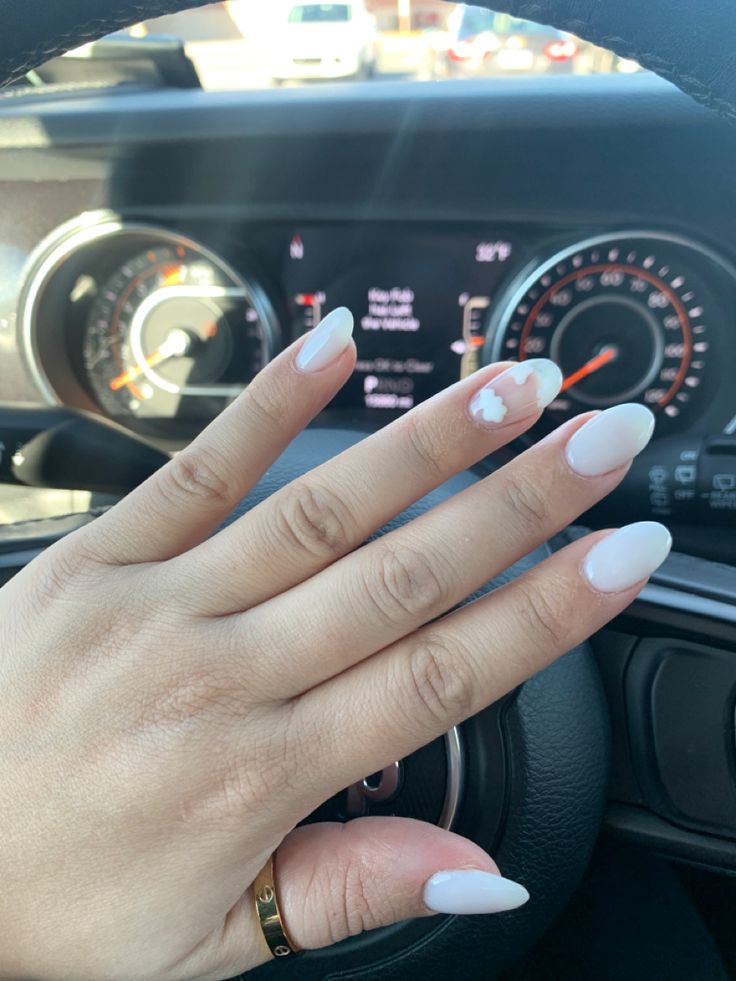 Chic Almond-Shaped Nails with Glossy White Polish and Playful Accent Design.