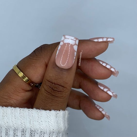 Stylish Chic Nude Nails with Playful White Detailing for a Trendy Look.