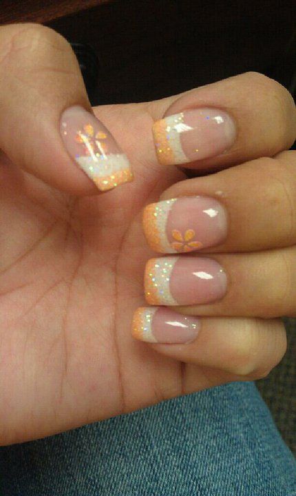 Cheerful Summer Nail Design: Soft Ombre Peach to White with Vibrant Floral Accents and Sparkling Tips.