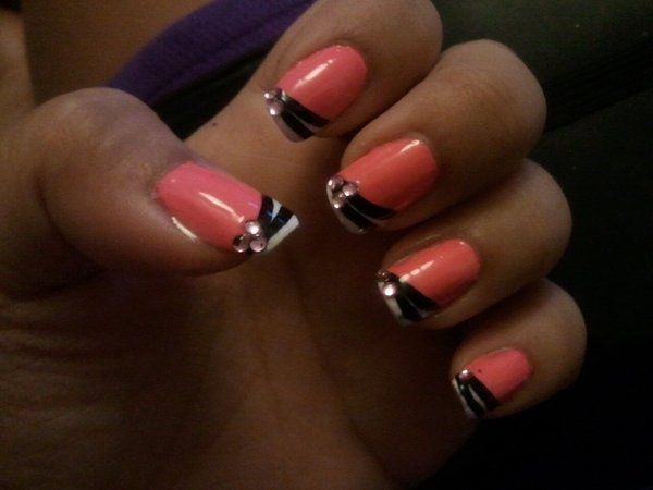 Chic Coral Nails with Sleek Black Stripes and Elegant Rhinestone Accents.