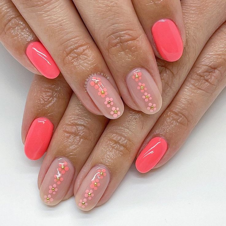 Vibrant Bright Coral Nail Design with Floral Accents in Solid and Nude Shades.