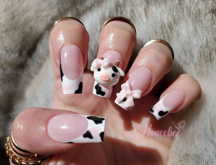 Whimsical Cow-Themed Nail Design: Pink and Glossy White Tips with 3D Charm and Spotted Accents.