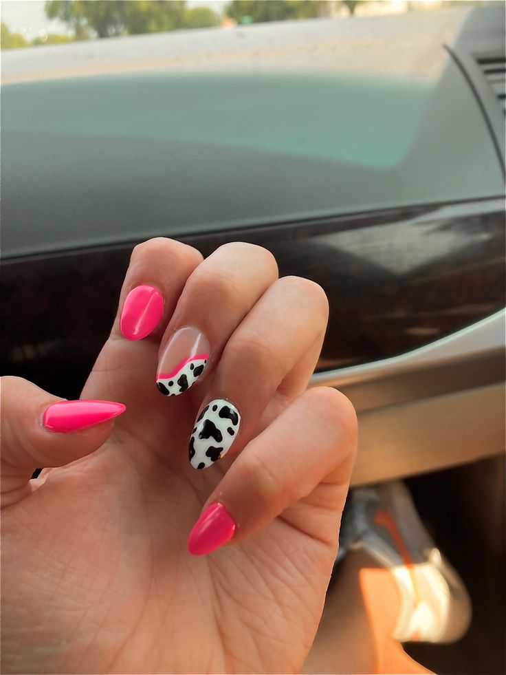 Trendy Bright Pink Nail Design with Playful Patterns and Chic Cow Print Accent.