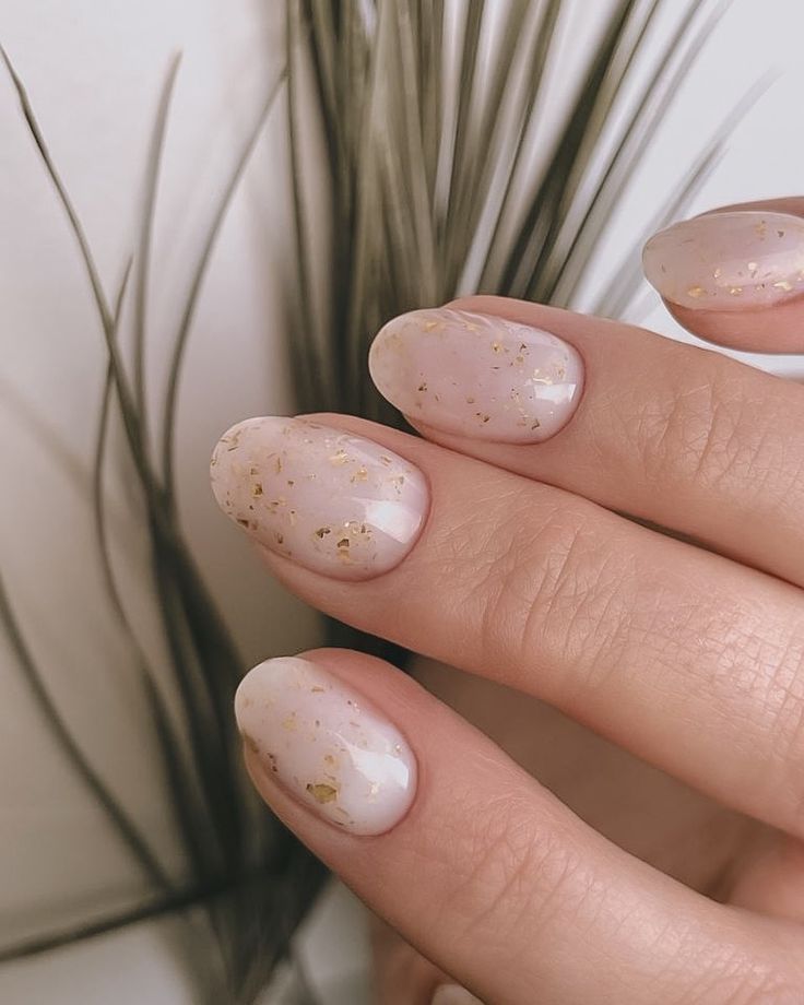 Sophisticated Soft Pink Nail Design with Delicate Gold Flakes for Understated Glamour.