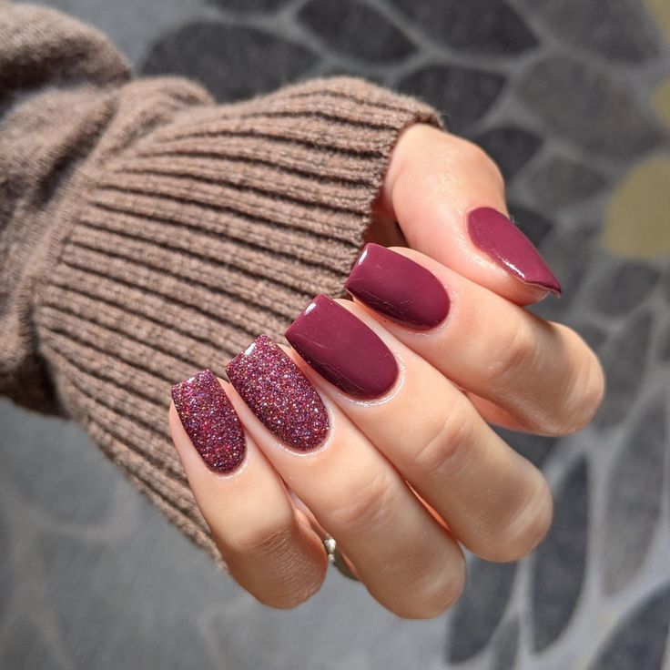 Sophisticated Burgundy Nail Design with Sparkling Glitter Accents.