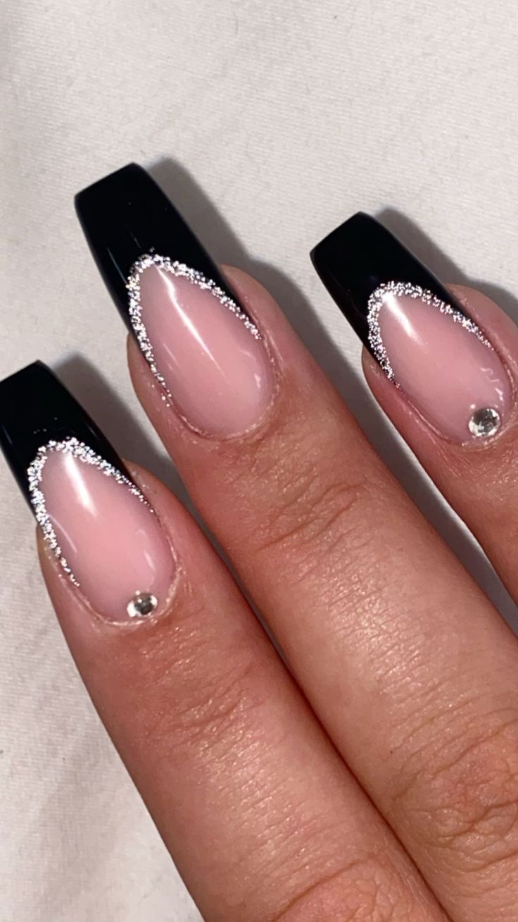 Sophisticated Black and Nude Nail Design with Glitter and Rhinestone Accents.