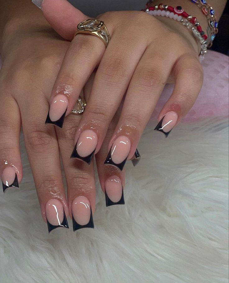 Elegant Nail Design: Modern French Manicure with Bold Black Tips and Elongated Shape.