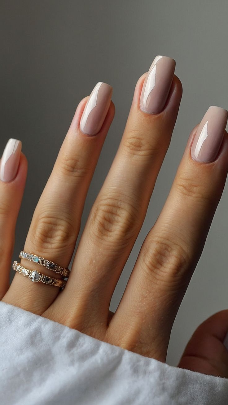 Chic Soft Pink and Nude Nail Design with Glossy Finish and Gold Accents.