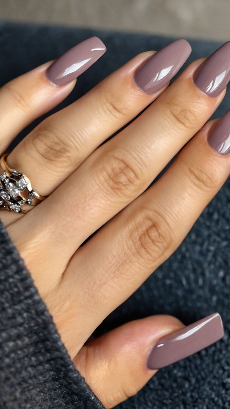 Chic Soft Mauve Nails with Glossy Finish and Delicate Ring for a Modern Look.