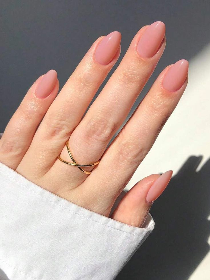 Sophisticated Almond-Shaped Nude Nails with Glossy Finish and Delicate Gold Ring.