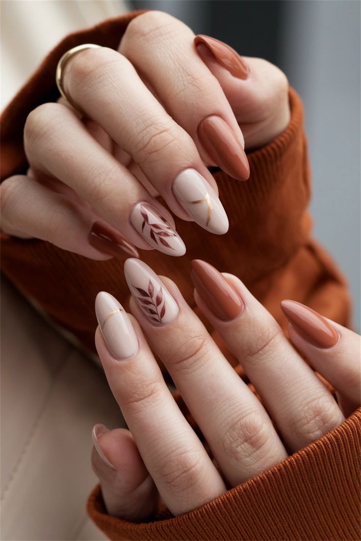 Elegant Almond-Shaped Nail Design in Earthy Tones with Botanical Accents and Gold Detailing.