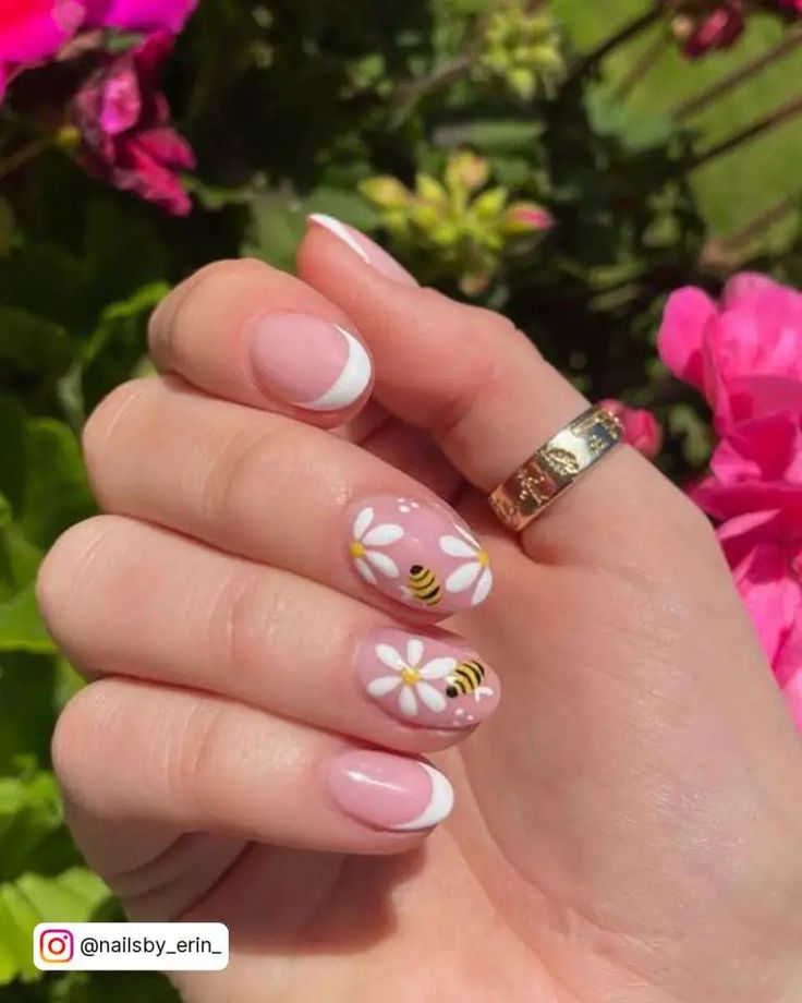 Charming Spring-Inspired Nail Design with Pink Base, French Tips, Daisies, and Bee Motifs.