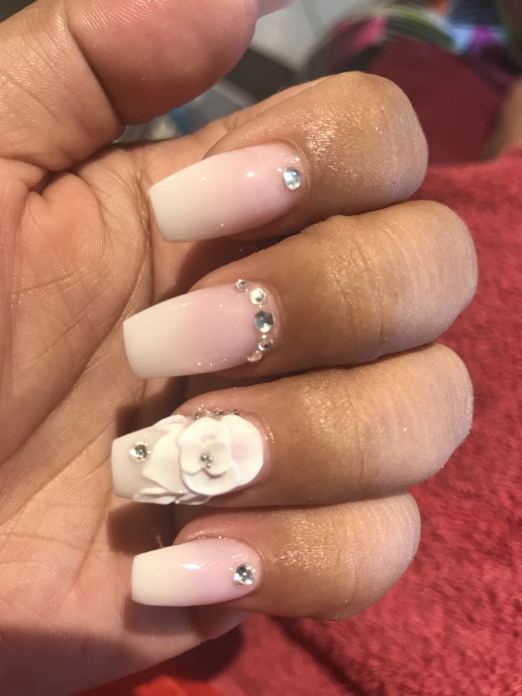 Sophisticated Pale Pink Gradient Nail Design with Floral Embellishments and Sparkling Cuticle Gems.