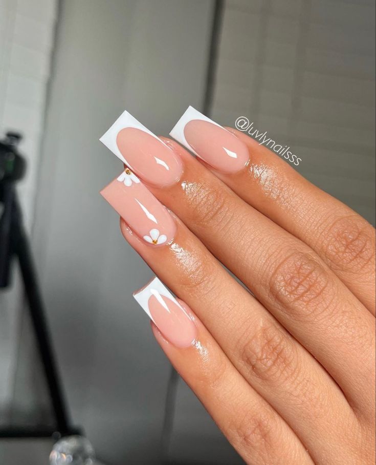 Chic Nude Nail Design with White Floral Accents and Glossy Finish