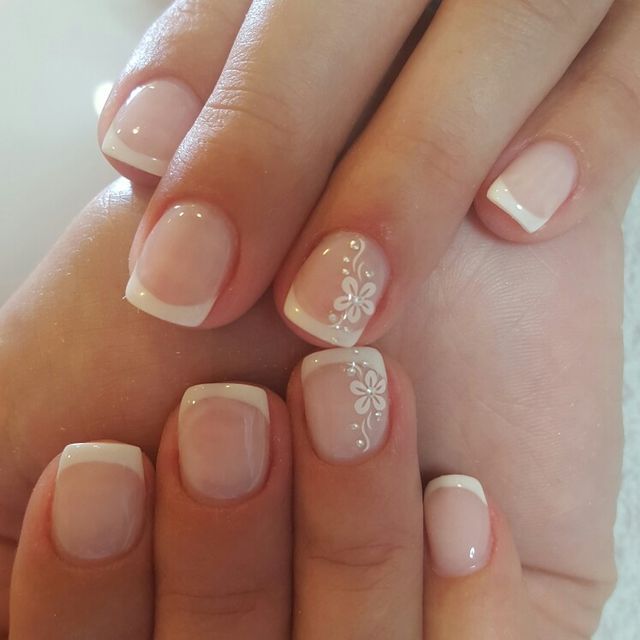 Elegant French Manicure with Floral Accents: A Classic Yet Feminine Touch.