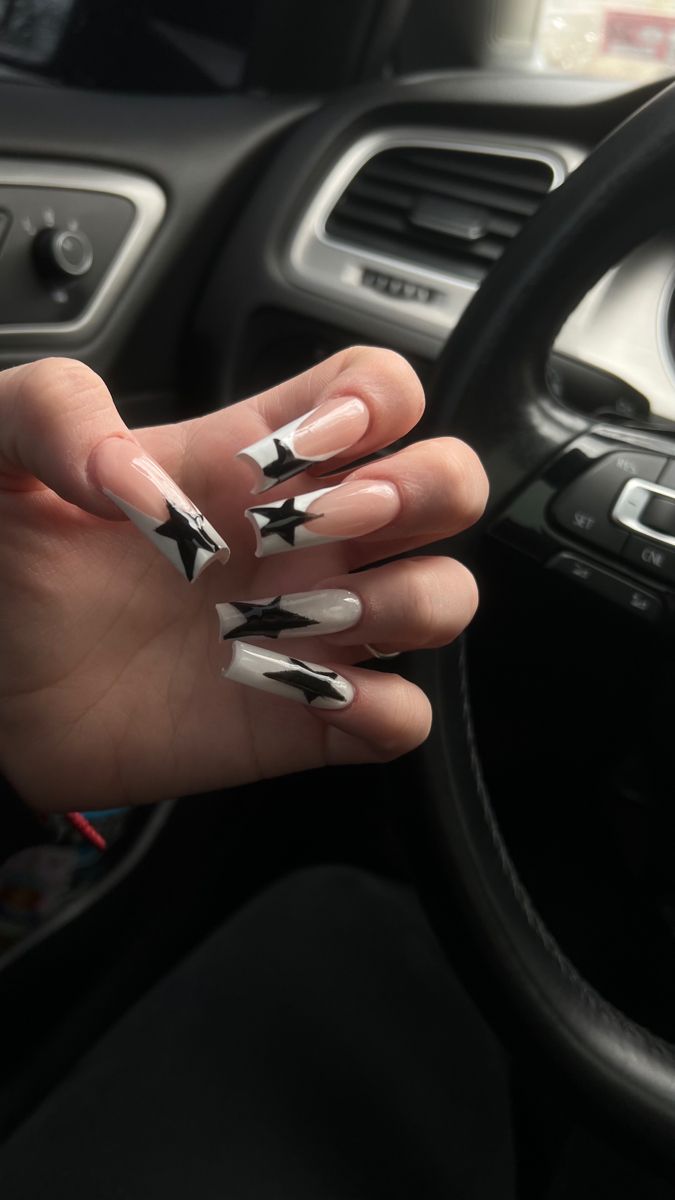 Elegant Nude and Black Nail Design with Sharp Star Motifs for Bold Creativity.