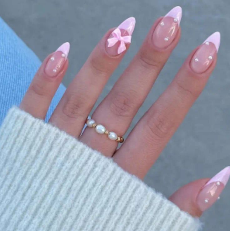 Charming Pink French Tips with Bow Accents and Pearls for a Playful Elegant Look.