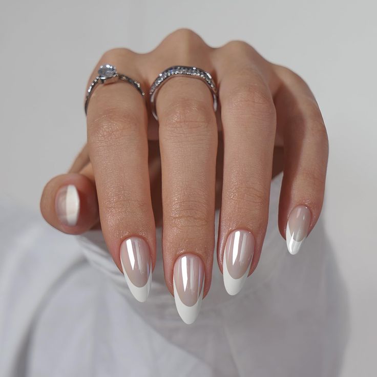 Chic Minimalist French Manicure: Elegant Neutral Beige and White Design with Pointed Tips and Delicate Rings.