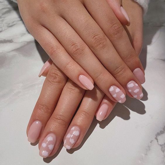 Charming Soft Pink Nail Design with Playful White Hearts