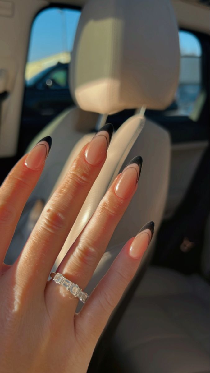 Chic Nude and Black Elongated Nail Design with Sparkling Ring Accent.