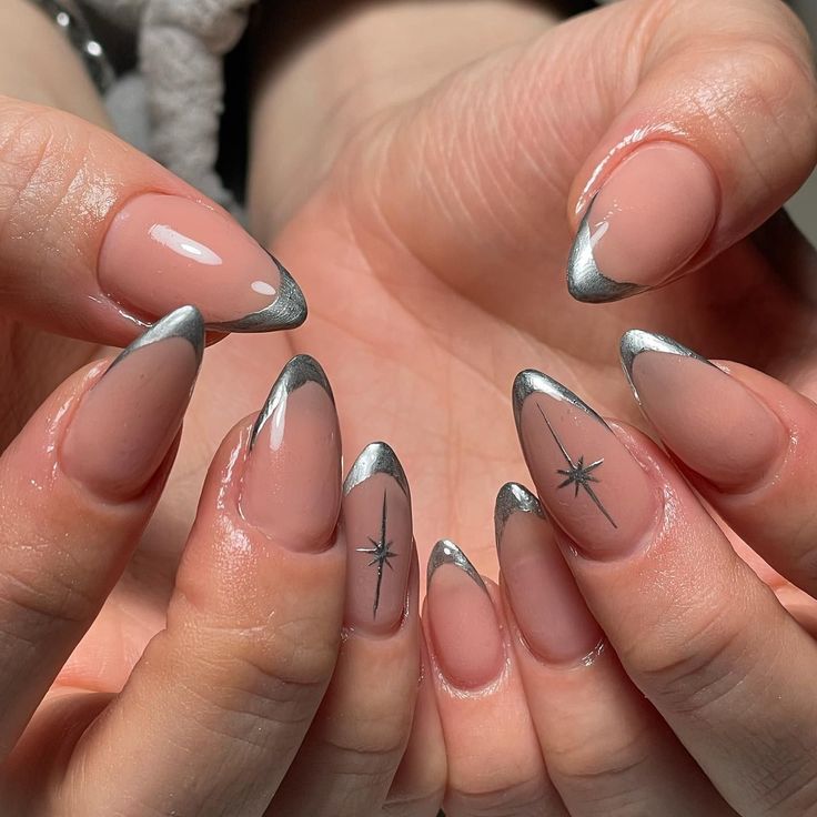 Chic Almond-Shaped Nail Design: Nude Base with Silver Tips and Minimalist Black Stars.