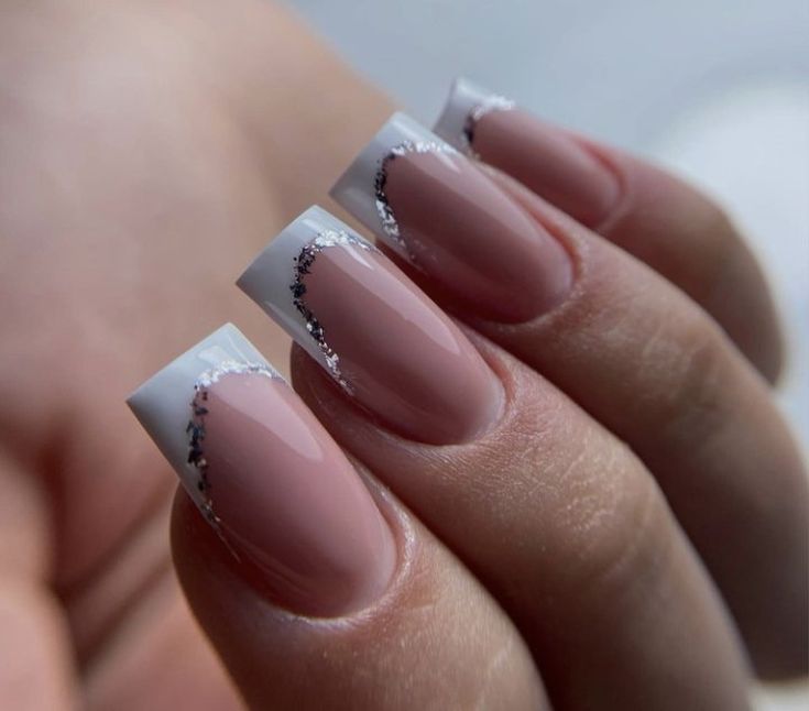 Sophisticated Glossy Nude Nail Design with White Tips and Silver Accents