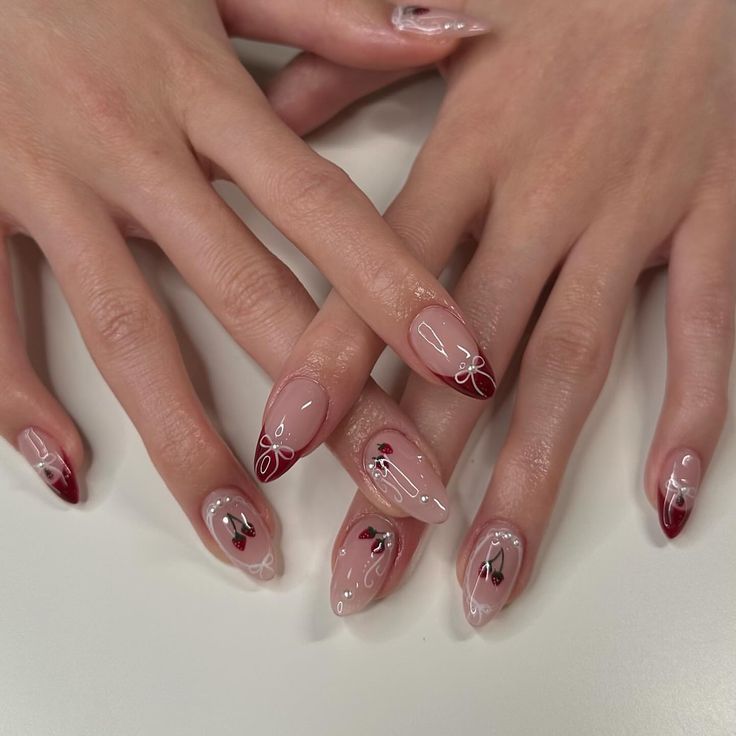 Refined Nail Design: Soft Nude Base with Deep Red Accents and Intricate White Line Art.