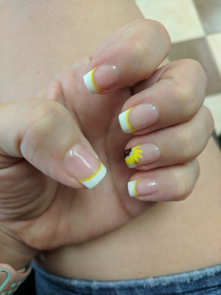 Chic French Tip Nail Design with Vibrant Yellow Accents and Cheerful Sunflower Detail.