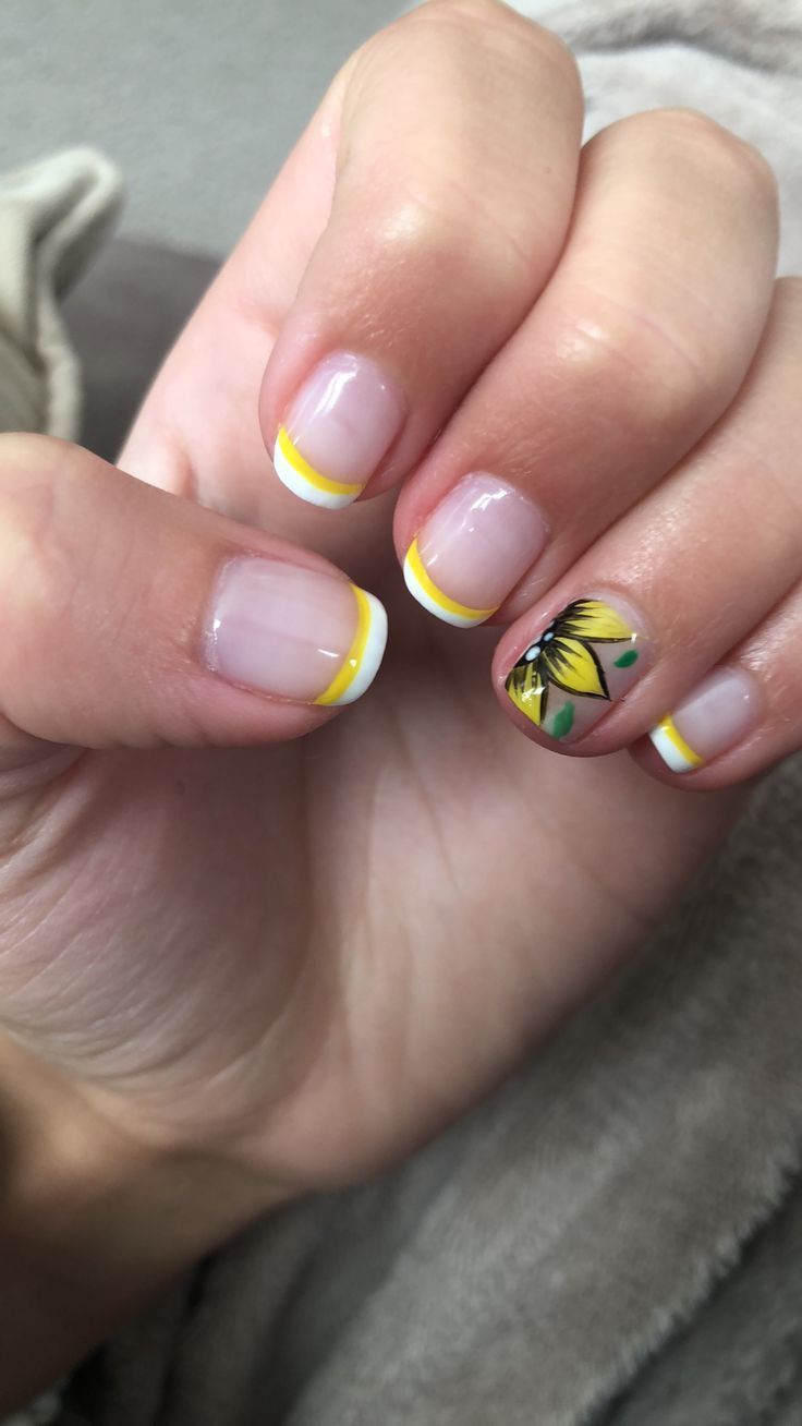 Cheerful Yellow and White French Tip Nail Design with Floral Accent