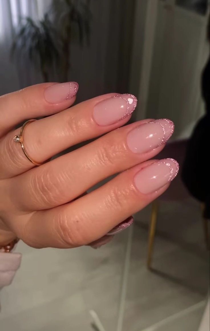 Chic Almond-Shaped Nails: Soft Pink Base with Glittery Tips for Effortless Glamour.