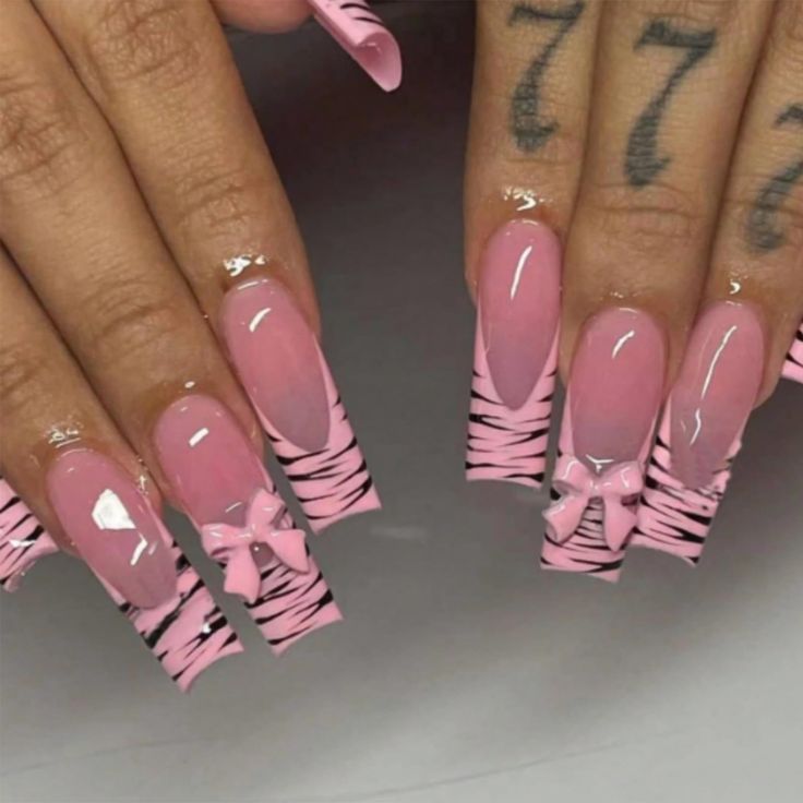 Trendy Nail Design: Soft Pink and Bold Zebra Stripes with Feminine Bow Accents.