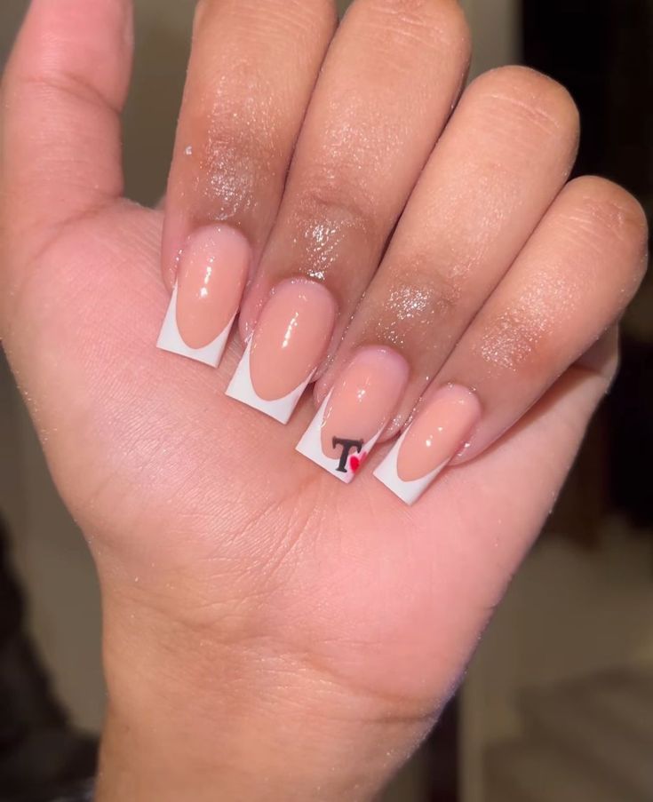 Chic French Manicure with Nude Base, White Tips, and Unique Graphic Element.