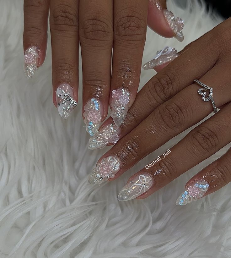 Elegant Translucent and Pastel Pink Nail Art with Intricate Floral Designs and Glamorous Gemstones.