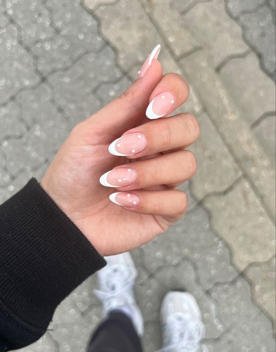 Sophisticated French Tip Nail Design with Glossy Nude Base and Playful Dotted Accents.