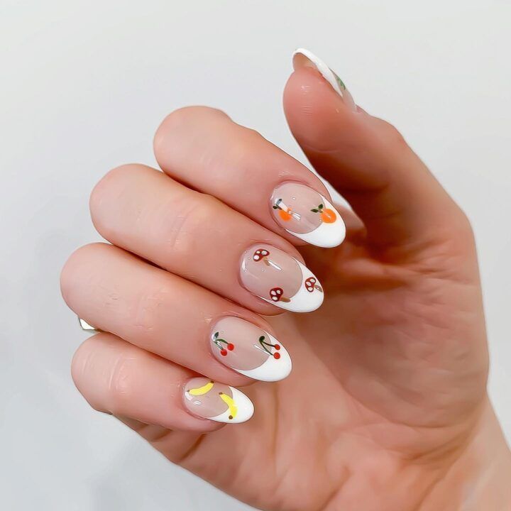 Playful French Tip Nail Design with Whimsical Fruit Motifs for a Fresh Summer Look.