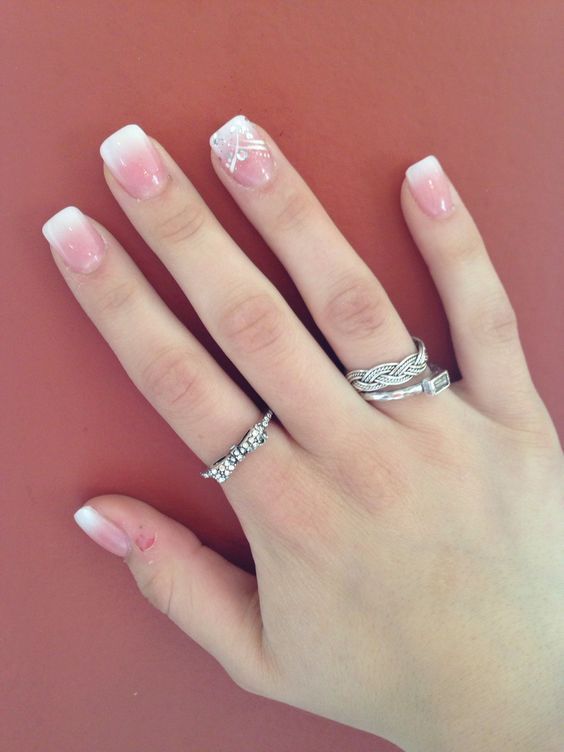 Sophisticated Soft Pink Ombre Nail Design with Charming Accents.