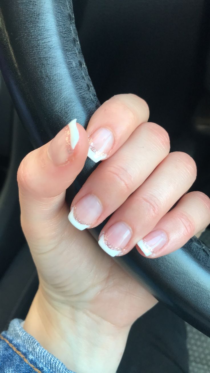 Classic Elegant French Tip Manicure with Glitter Accents and Subtle Nude Base.