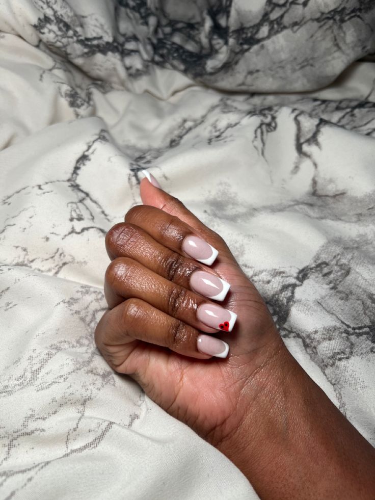 Chic Nude and White Nail Design with Playful Red Heart Accent