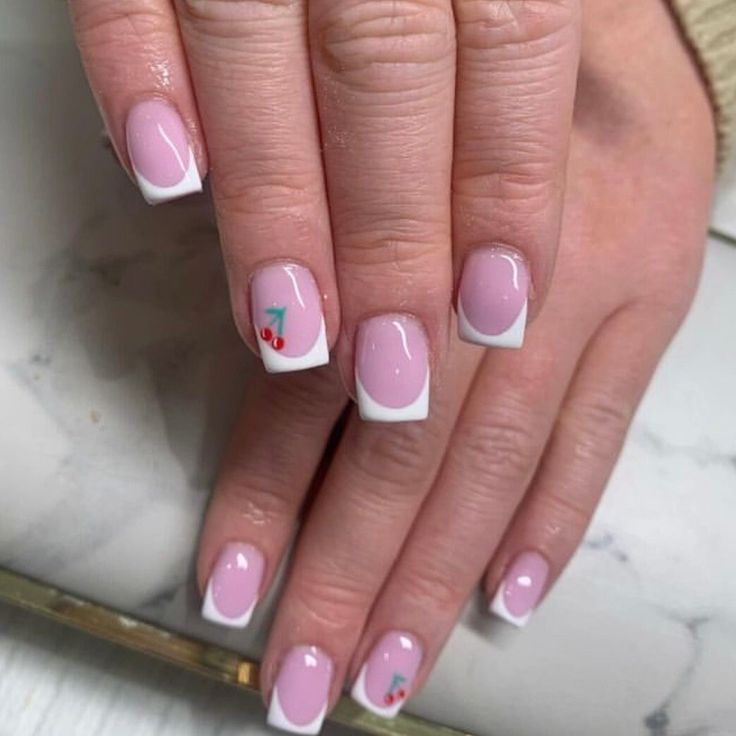 Elegant Soft Pink Nails with White Tips and Playful Cherry Motifs.