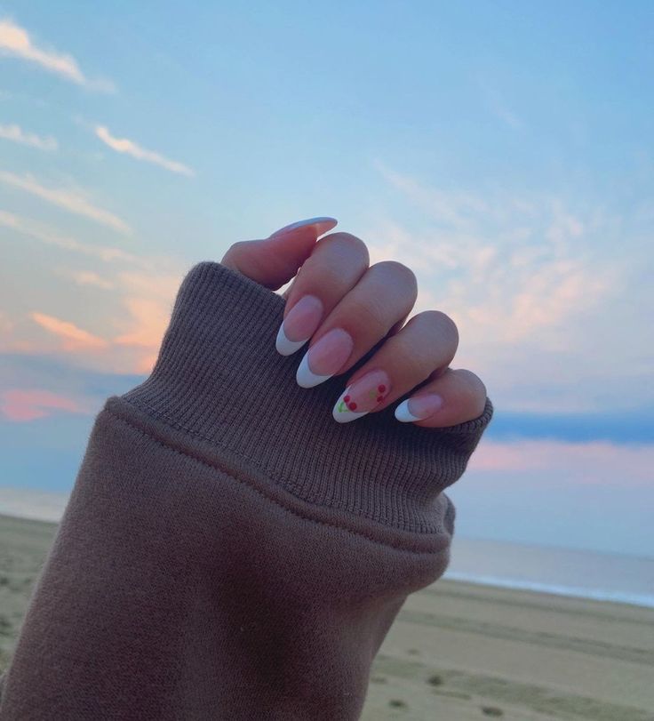 Chic French Tip Nail Design with Floral Accents and Relaxing Beach Vibes.