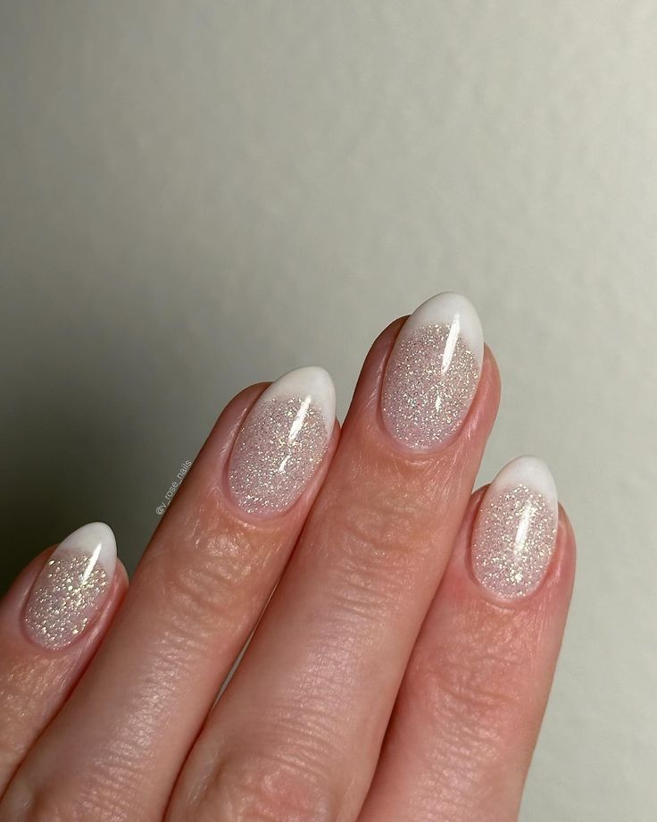 Sleek Ombre Nail Design with Chic White Tips and Glamorous Glitter Base.