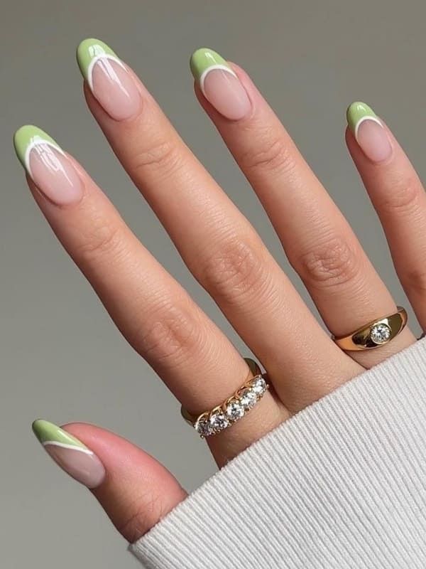 Chic Modern French Manicure: Elegant Green and Nude Design with Pointed Tips and White Accents.