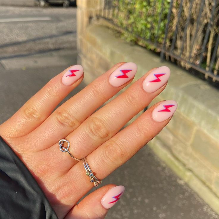 Bold Almond-Shaped Nude Nails with Striking Red Lightning Bolt Accents